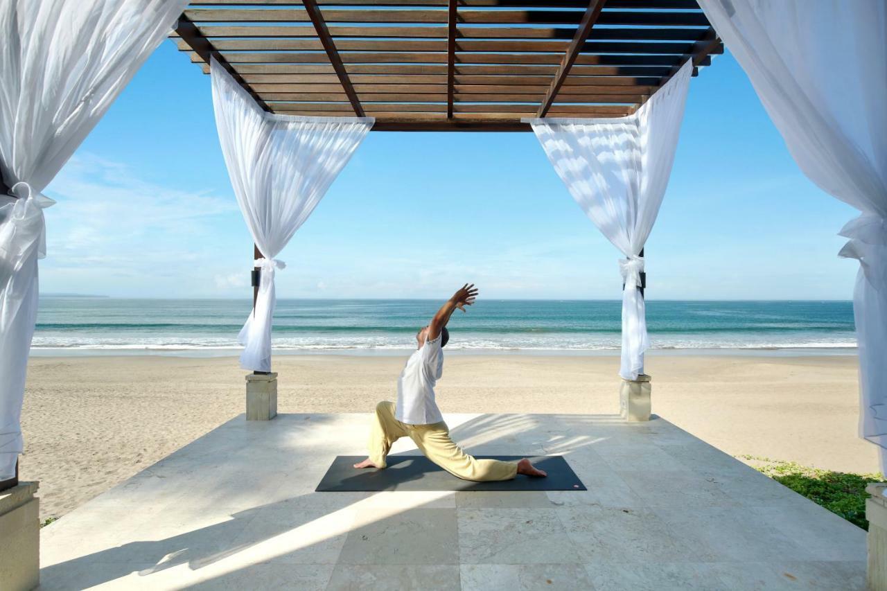 The Seminyak Beach Resort & Spa Esterno foto A man practicing yoga at the beach